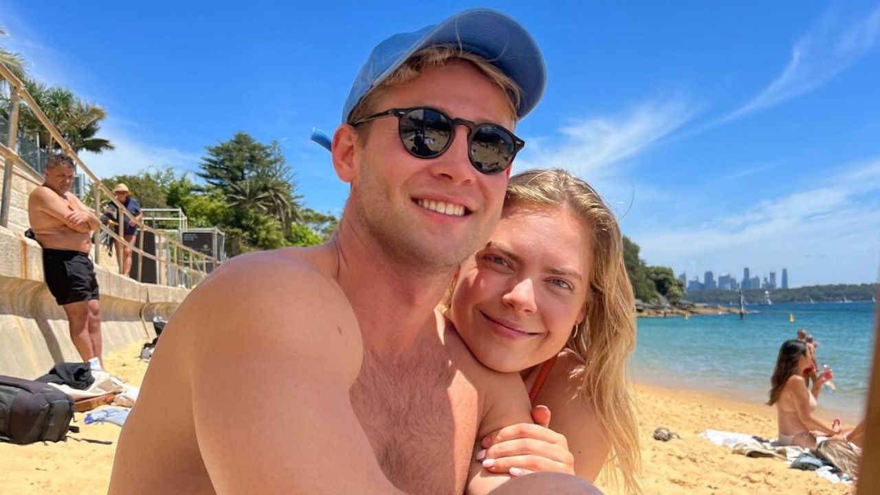 Millie and Tim casually hanging out on a beach.